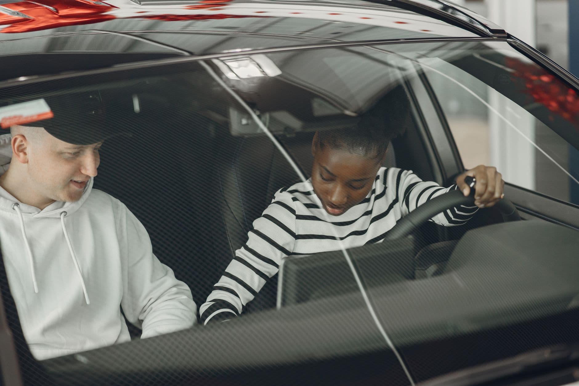 Körlärare och elev diskuterar inuti bilen under en körlektion i Sollentuna.