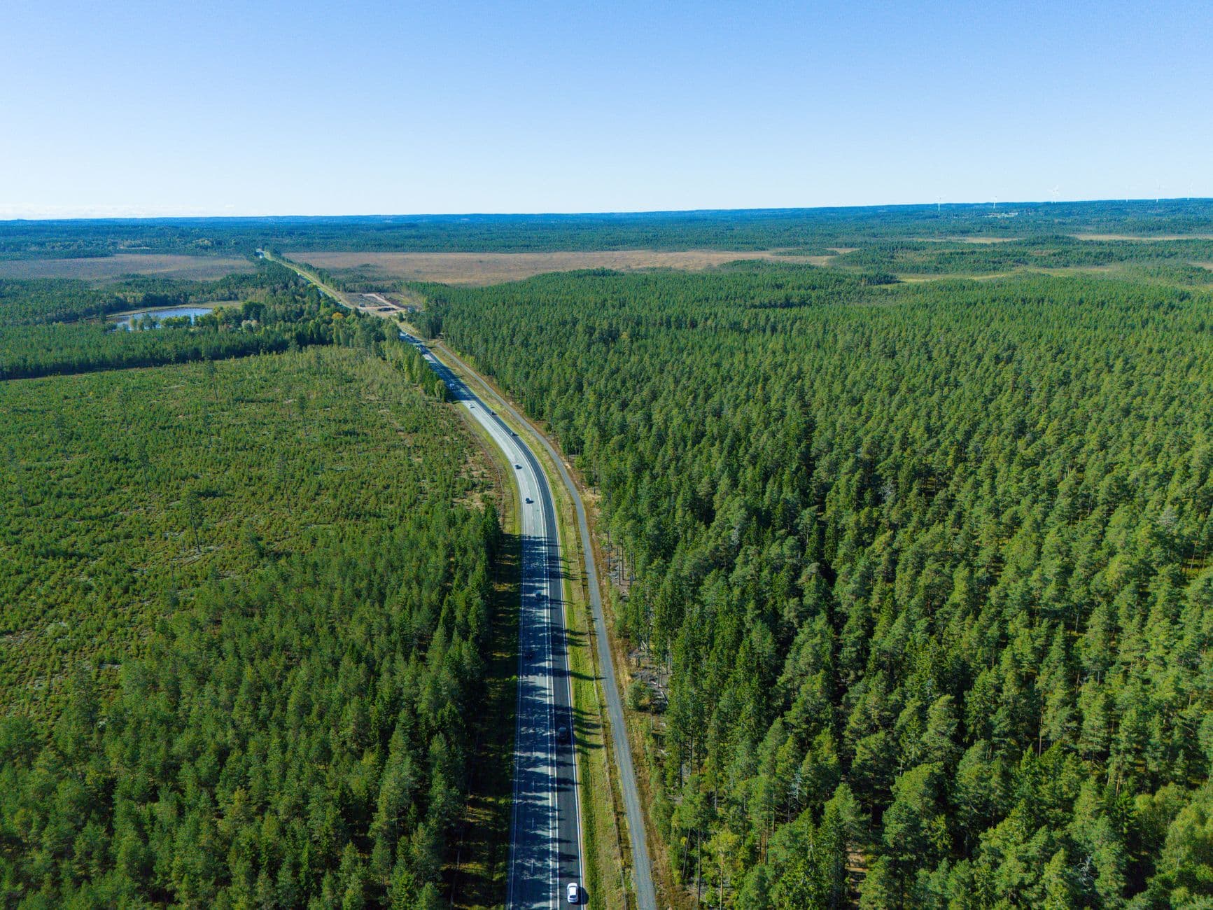 Flygfoto över motorväg genom skog i norra Stockholm — körkortsutbildning nära dig.